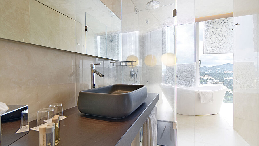 Bright bathroom with basin, freestanding bathtub and scenic view at Maritim Hotel Plaza Tirana