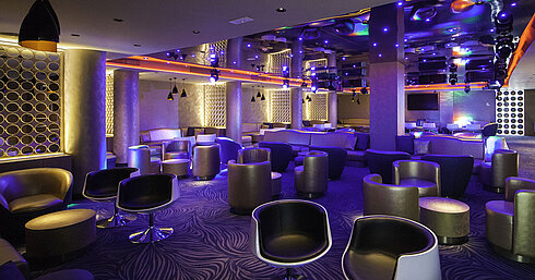 Modern hotel lounge with stylish seating, decorative lighting and a club-like atmosphere