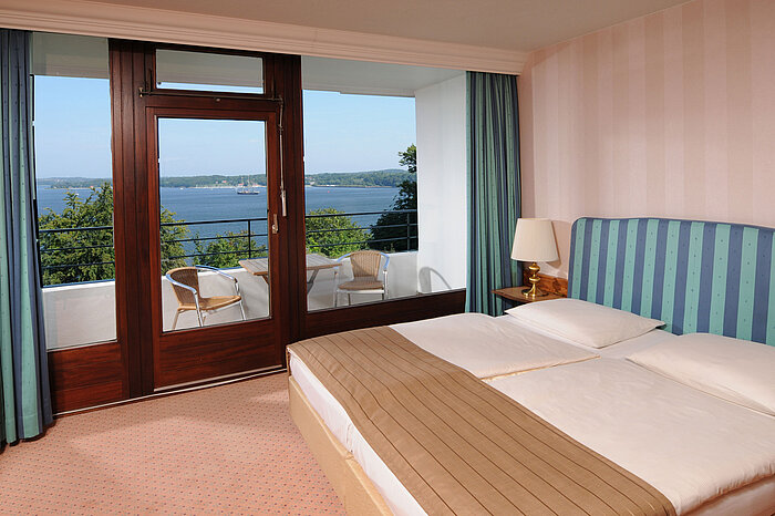 Junior suite Junior Suite in the Maritim Hotel Kiel, double bed, balcony with seating and view of the Kiel Fjord.