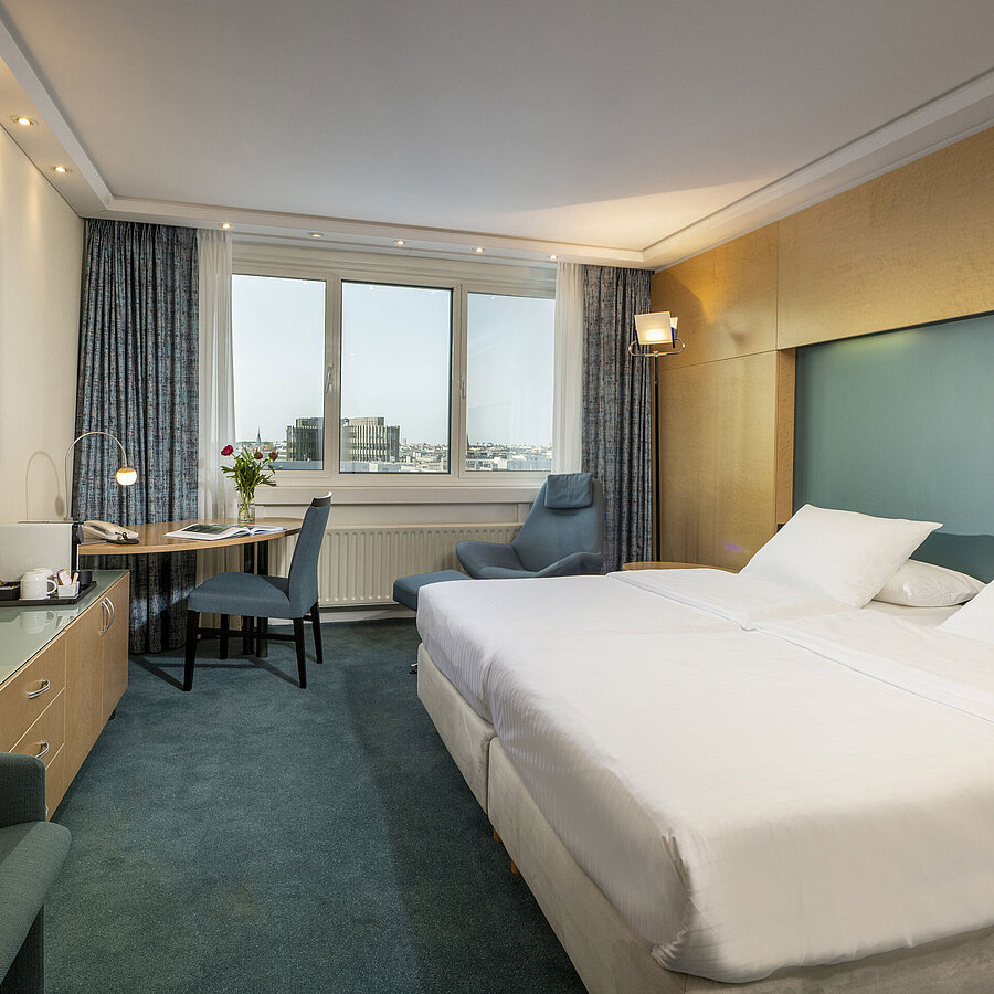 Modernly furnished Superior room at Maritim proArte Hotel Berlin with large bed, desk, artwork, and city view from the window