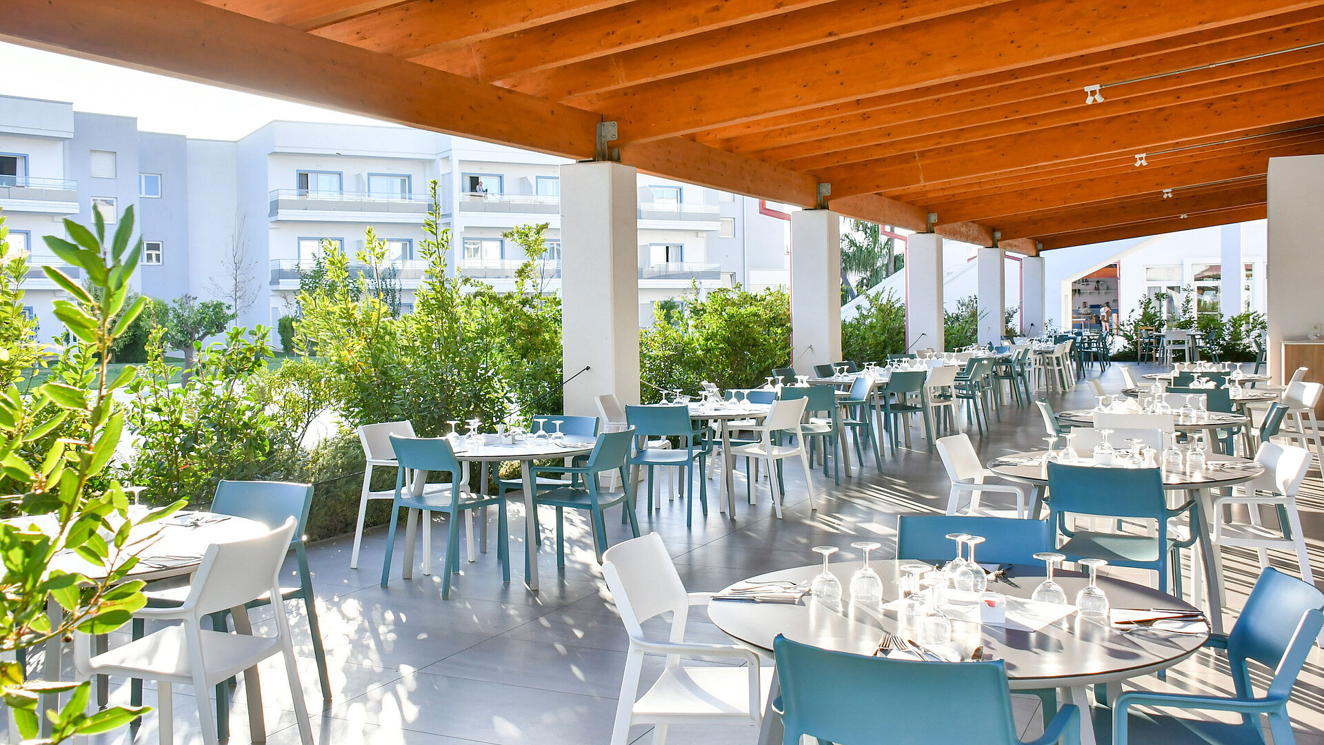 Bright covered outdoor restaurant area at Maritim Resort Calabria with set tables