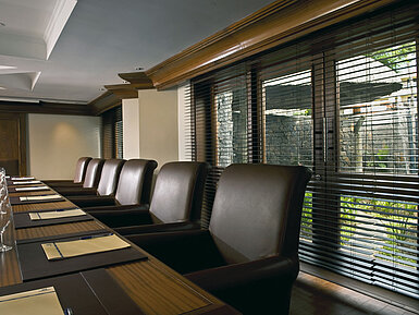 Modern conference room with meeting table, leather chairs and natural daylight