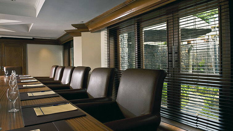 Modern conference room with meeting table, leather chairs and natural daylight