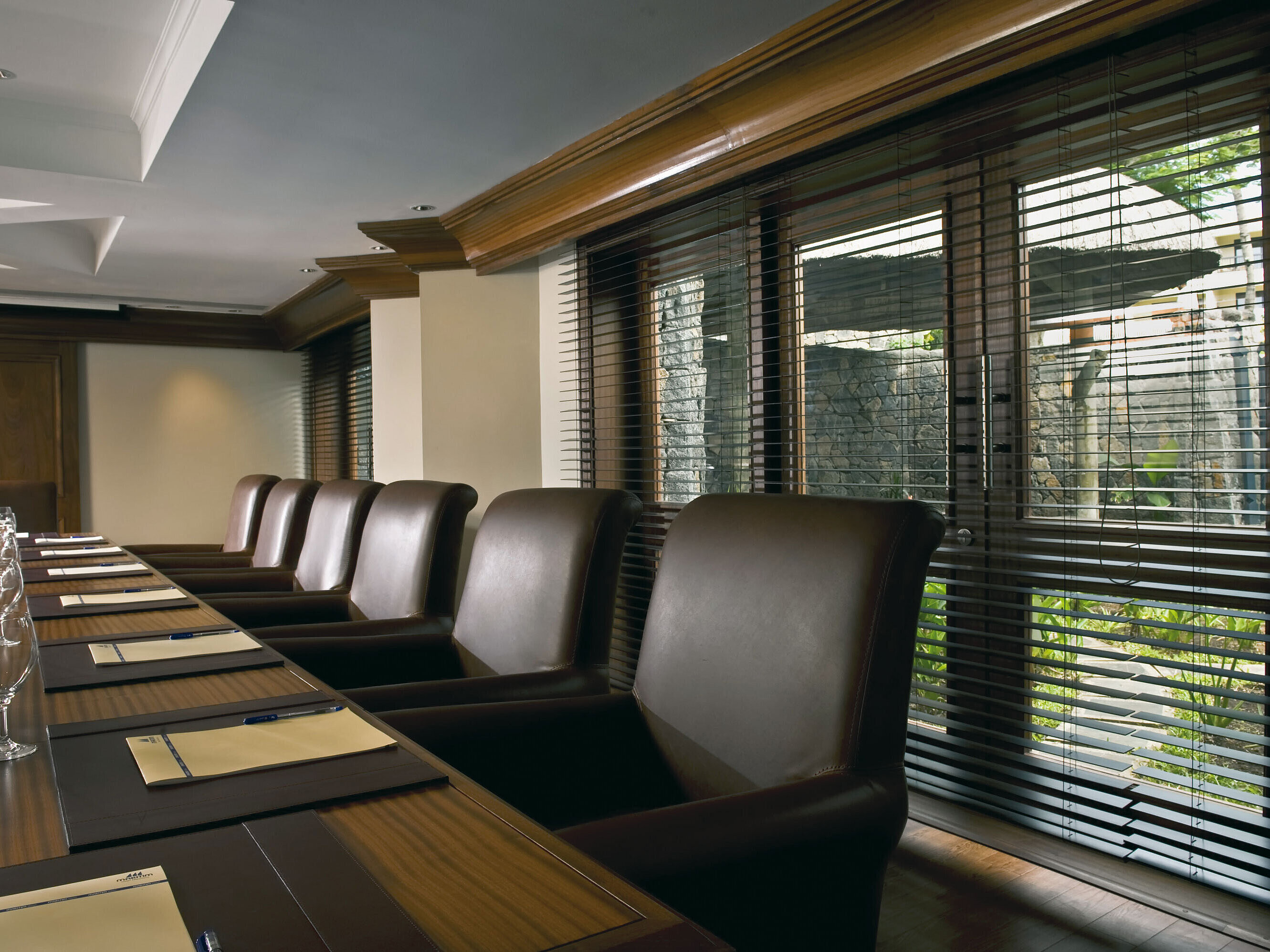 Modern conference room with meeting table, leather chairs and natural daylight