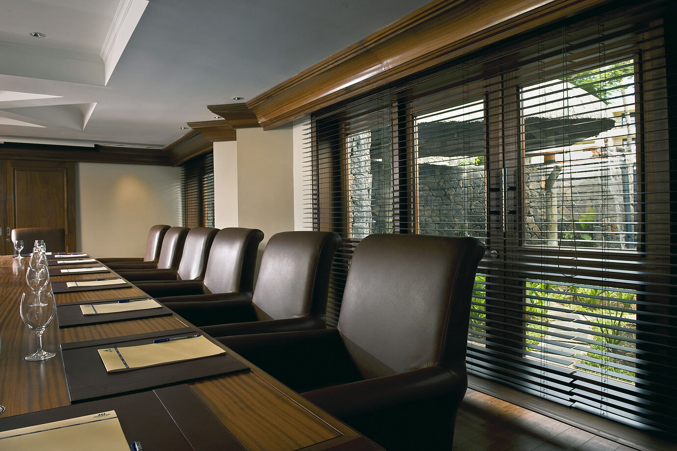 Modern conference room with meeting table, leather chairs and natural daylight