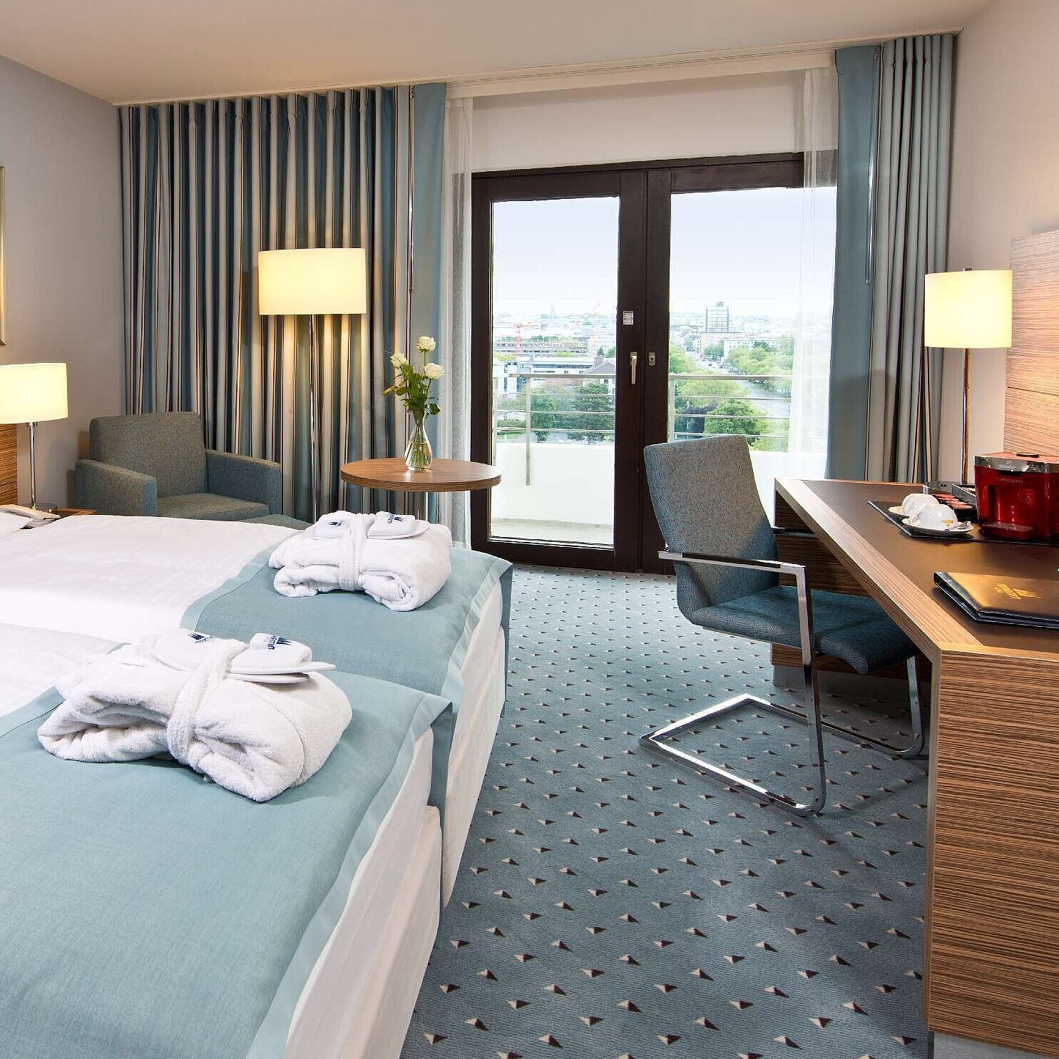 Superior room at Maritim Hotel Darmstadt featuring stylish design, desk, cozy seating area, and double bed with bathrobes.