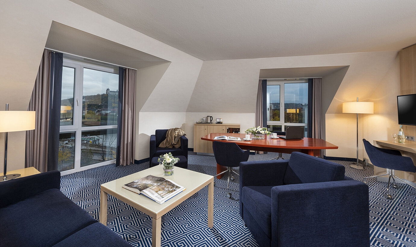 Spacious Grand Suite at Maritim Hotel Würzburg with seating area and view of Marienberg Fortress
