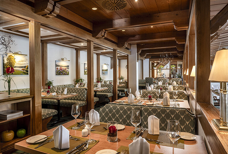 Cosy restaurant with wooden ceiling and elegantly set tables at Maritim Hotel Titisee