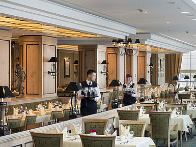 Restaurant 'Wintergarten' at Maritim Hotel Dresden with set tables and friendly staff.