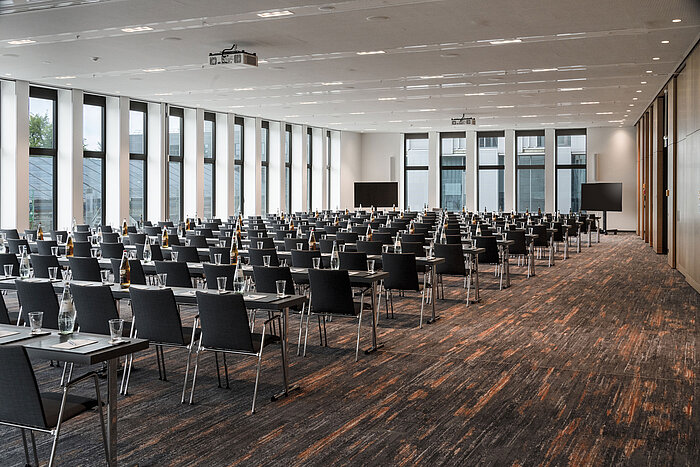 Large conference room at Maritim Hotel Ingolstadt with row seating, floor-to-ceiling windows and high-quality technology.