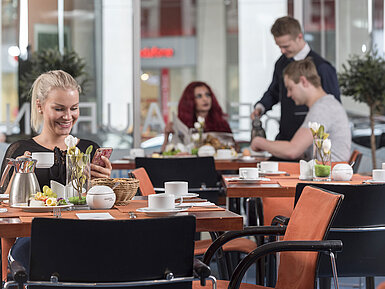 Guests enjoying breakfast at the restaurant of Maritim proArte Hotel Berlin.A friendly atmosphere with service and fresh food