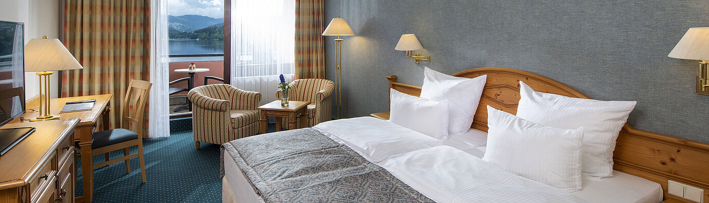Spacious room at Maritim TitiseeHotel with seating area and view of Lake Titisee