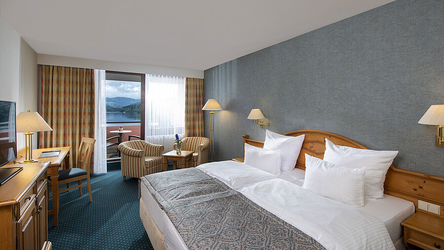 Spacious room at Maritim TitiseeHotel with seating area and view of Lake Titisee