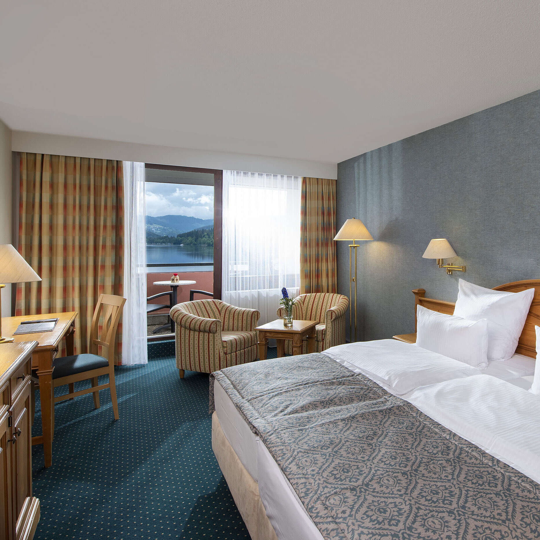 Spacious room at Maritim TitiseeHotel with seating area and view of Lake Titisee