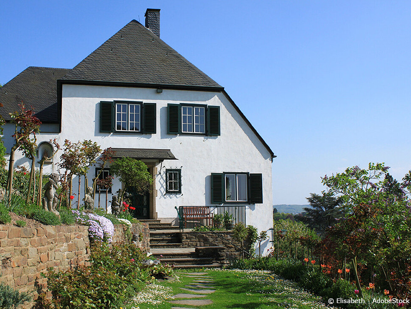 Adenauer House in Rhöndorf with garden and flower beds on a sunny day
