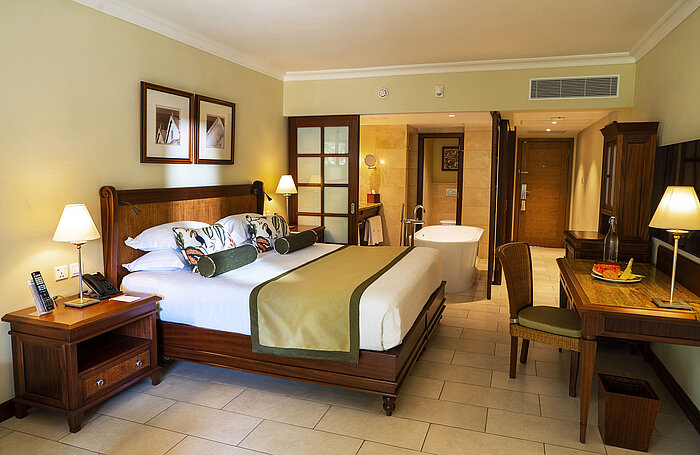 Spacious hotel room with freestanding bathtub, double bed and stylish interior