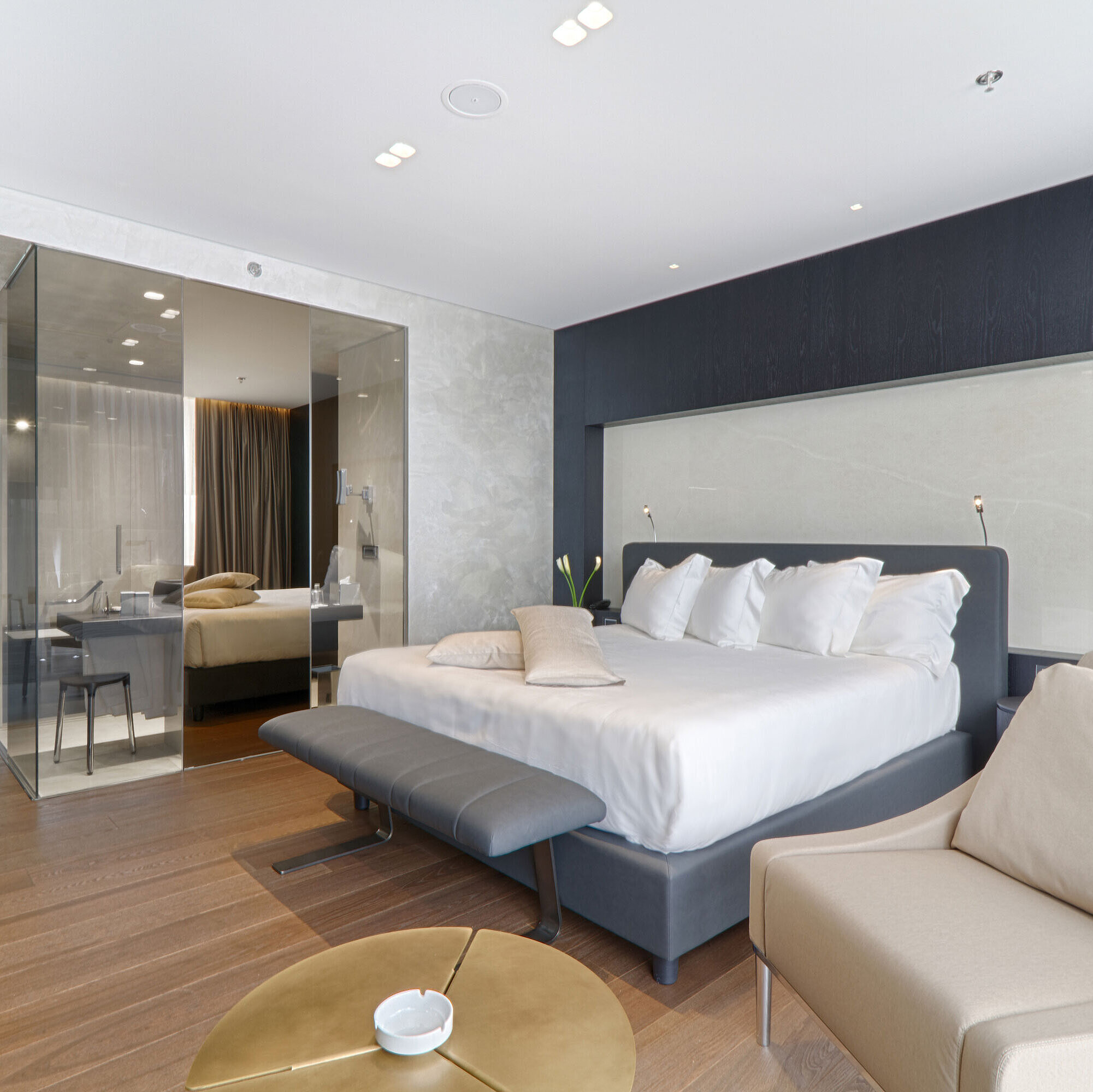 Spacious double room with armchair, glass partition and modern design at Maritim Hotel Plaza Tirana