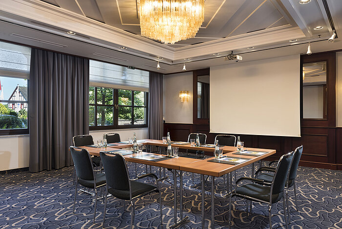 Bright meeting room with modern technology, large windows, and elegant chandelier at Maritim Hotel Königswinter.