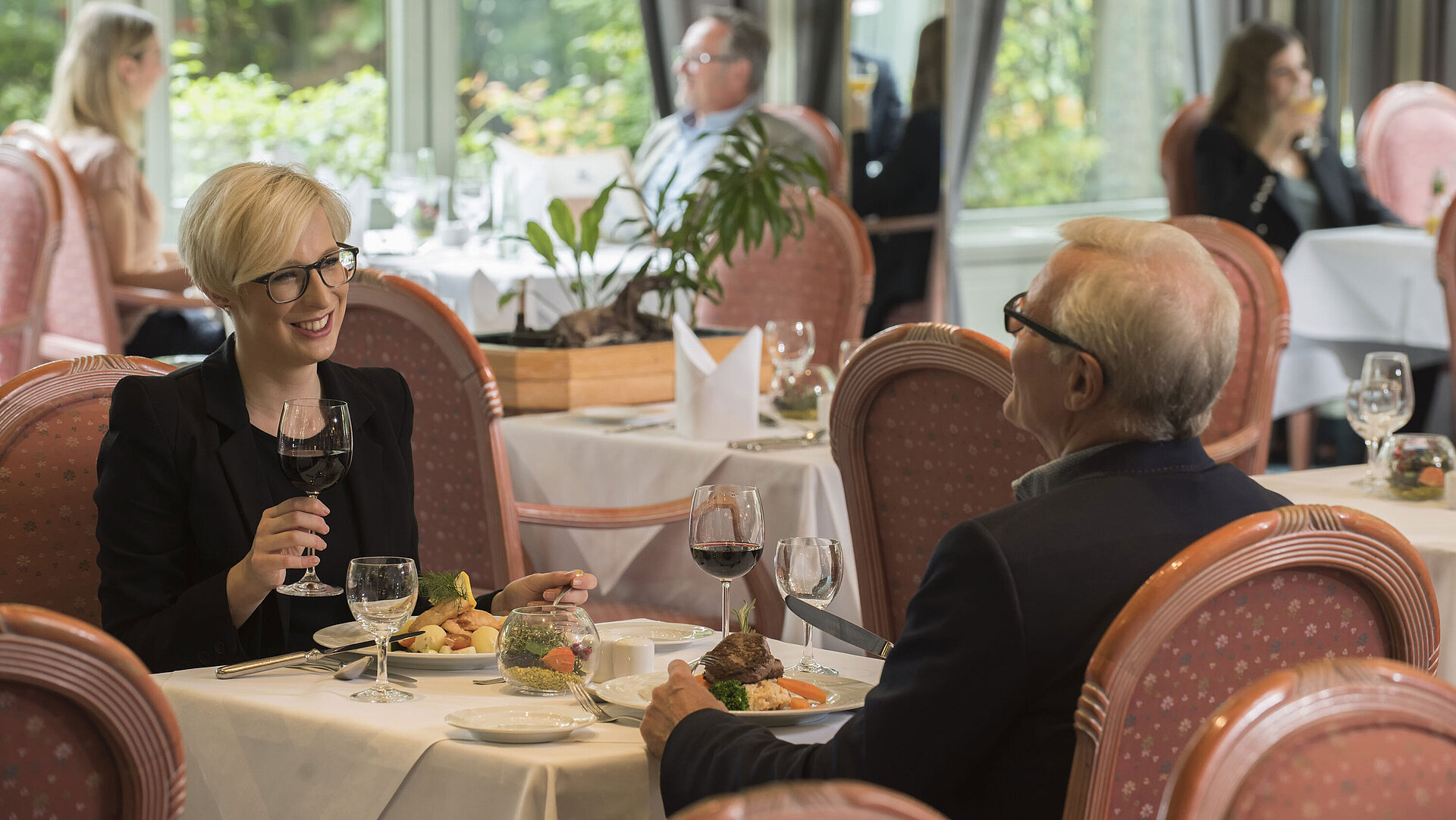 Guests dining at the stylish restaurant of Maritim Hotel Bad Salzuflen with garden view