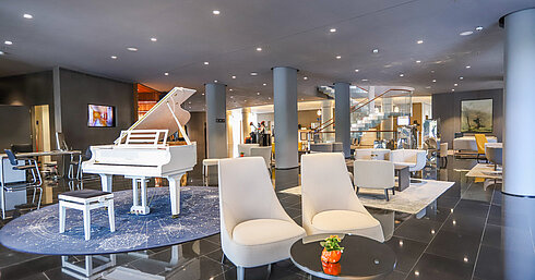 Elegant hotel lobby with white grand piano and stylish seating at Maritim Hotel Plaza Tirana