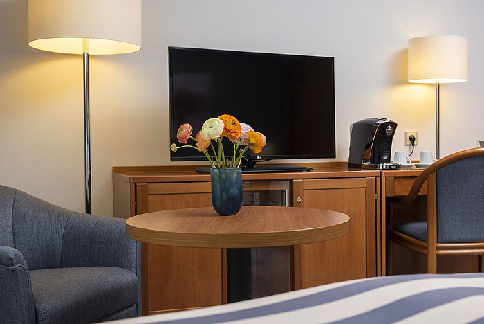 Bright family room at Maritim Hotel Ulm with large bed, seating corner and desk