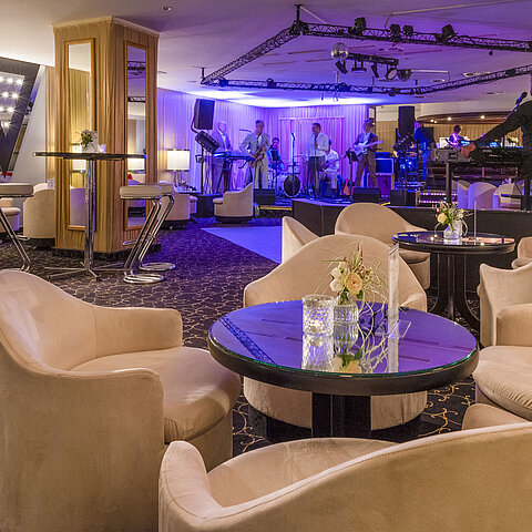 Elegant bar area with live band, atmospheric lighting and comfortable seating for guests.