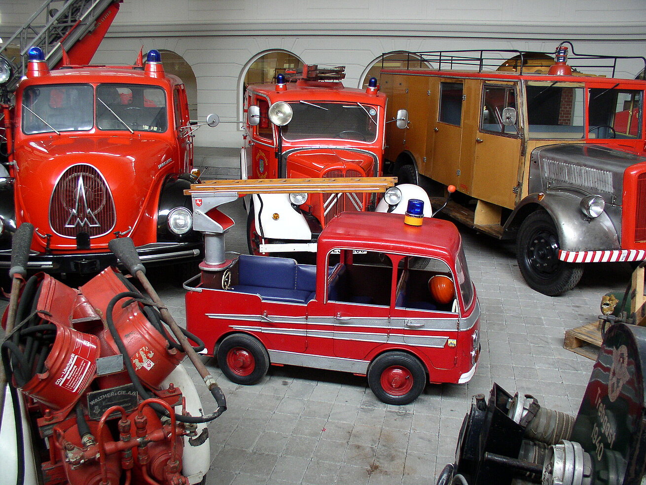 Historic fire engines and rescue vehicles displayed inside a firefighting museum