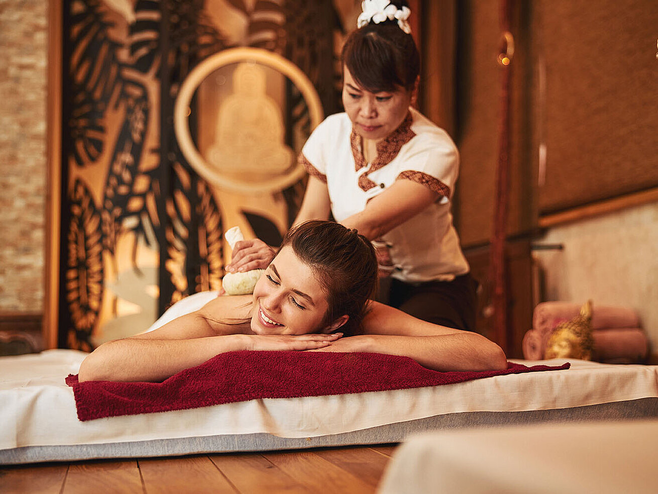 Relaxing back massage in spa with warm atmosphere and smiling therapist