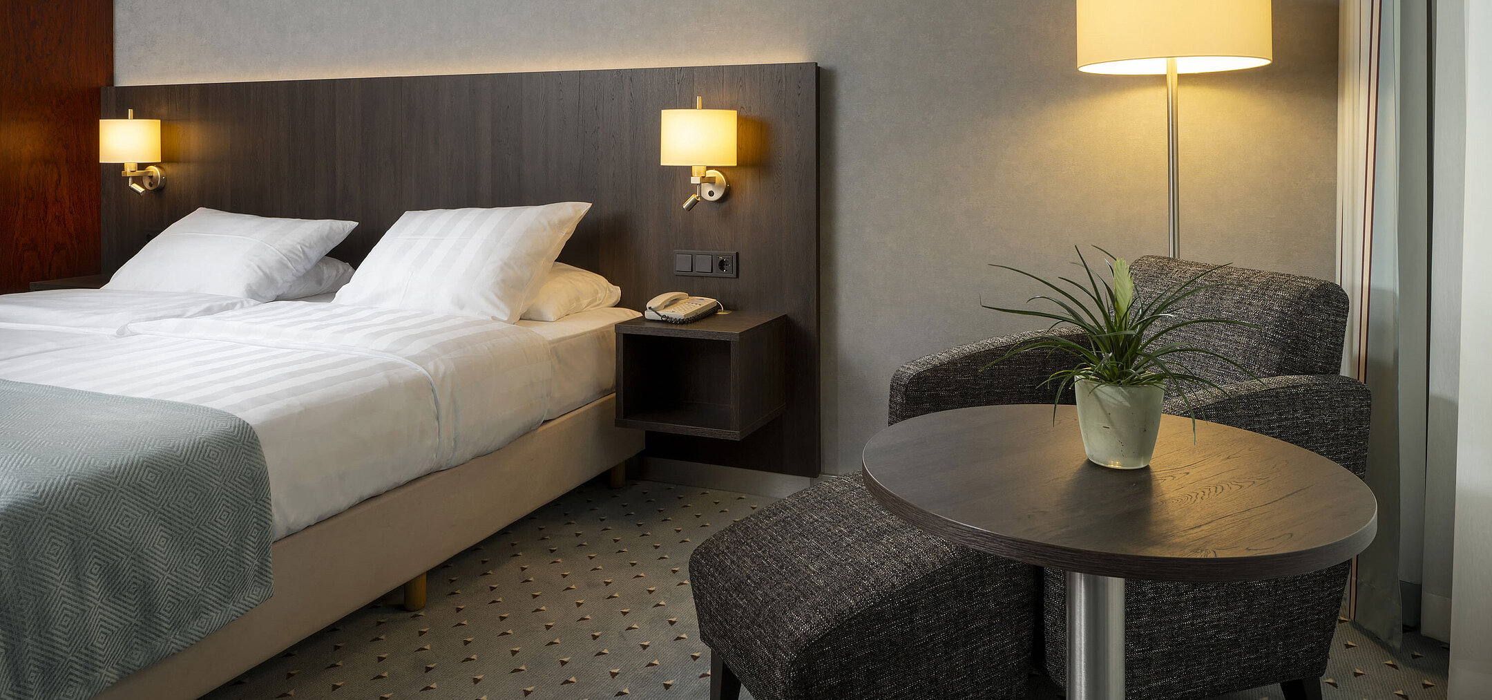 Comfortable single room at Maritim Hotel Bremen with cozy seating area, elegant lighting, and modern double bed.
