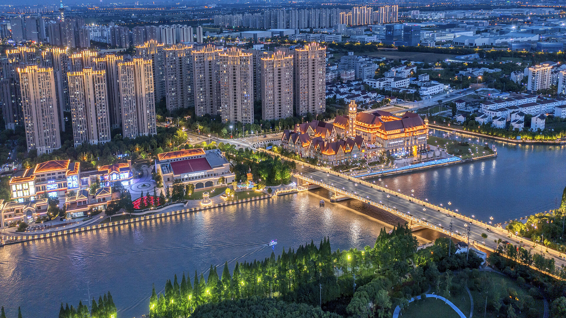 Night aerial view of Maritim Hotel Taicang and city with illuminated bridges and high-rises