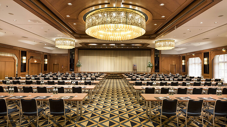 Elegant conference hall with stage, chandeliers, and modern seating at Maritim Hotel Königswinter.