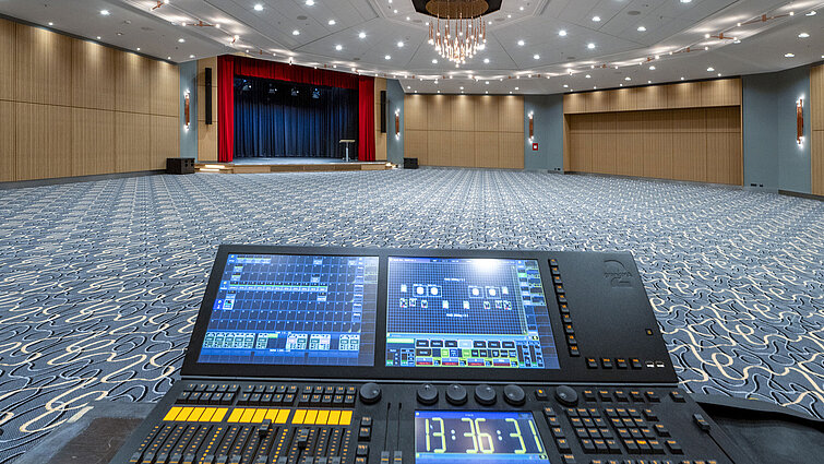 Modern event hall Barbarossa at Maritim Hotel Würzburg, featuring a stage and lighting controls for conferences and events.
