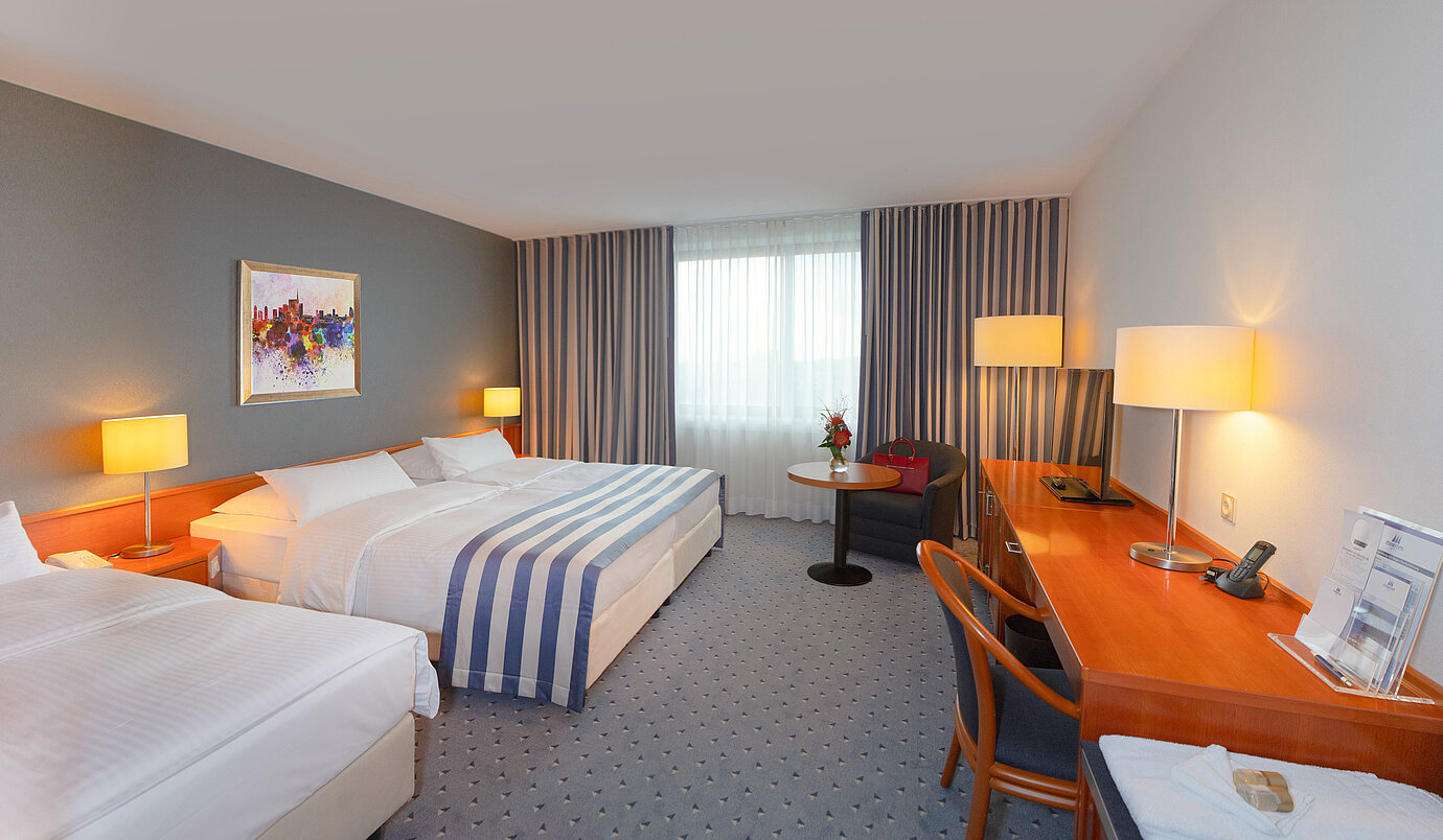 Family room at Maritim Hotel Ulm with cozy seating area and warm colors.