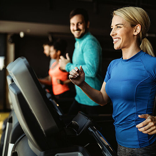 Hotel guests exercising on treadmills in hotel fitness room