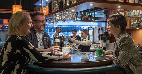 Guests chatting and enjoying drinks at the bar of Maritim Hotel Travemünde