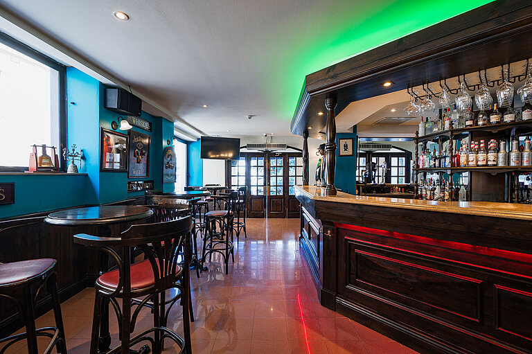 Bar Stylish pub bar at Maritim Antonine Hotel & Spa Malta featuring dark wood interiors, a selection of spirits and cosy seating areas.