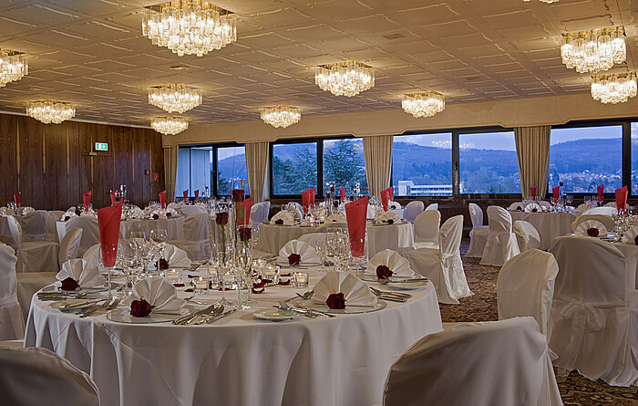 Spacious banquet hall with round tables and elegant decor at Maritim Hotel Bad Salzuflen