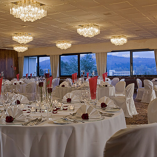 Spacious banquet hall with round tables and elegant decor at Maritim Hotel Bad Salzuflen