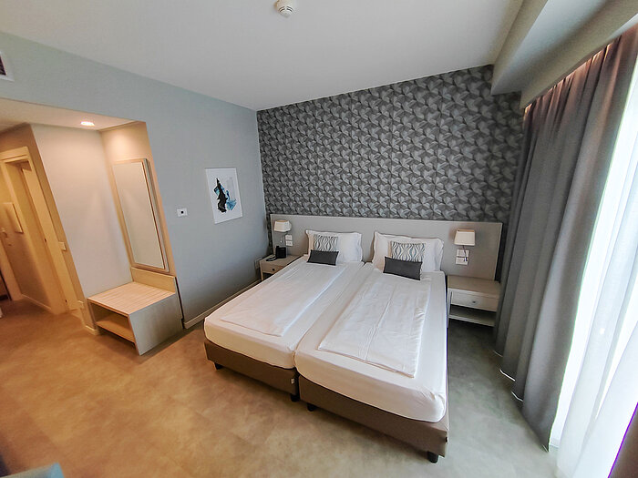 Modern hotel room at Maritim Resort Calabria with twin bed, desk and mirror