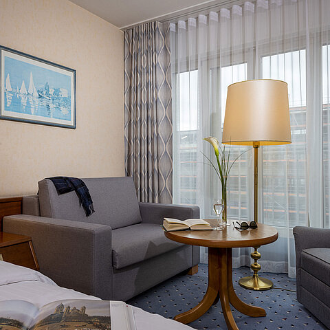 Comfort room at the Maritim Hotel Köln, with a cozy sitting area, reading table and modern furnishings.