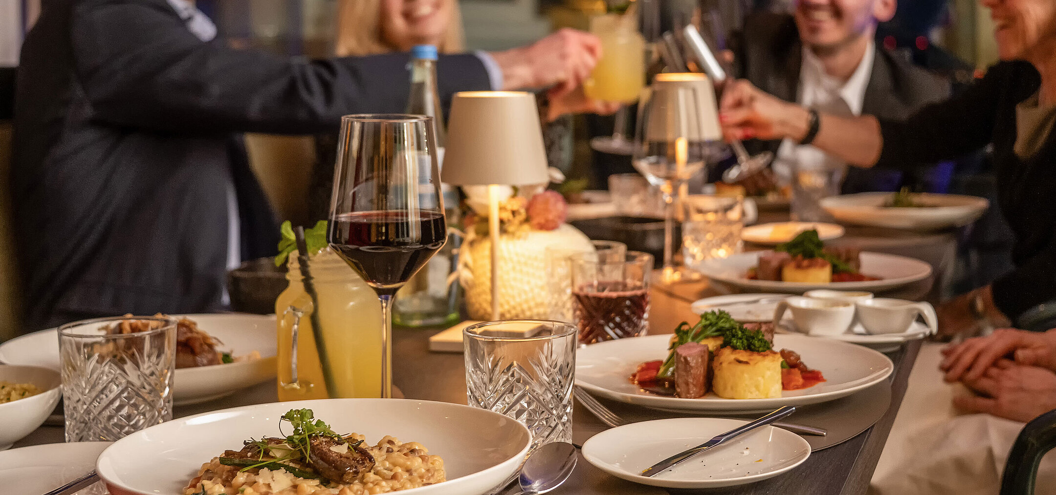Guests enjoying dinner together in a restaurant at an elegantly set table