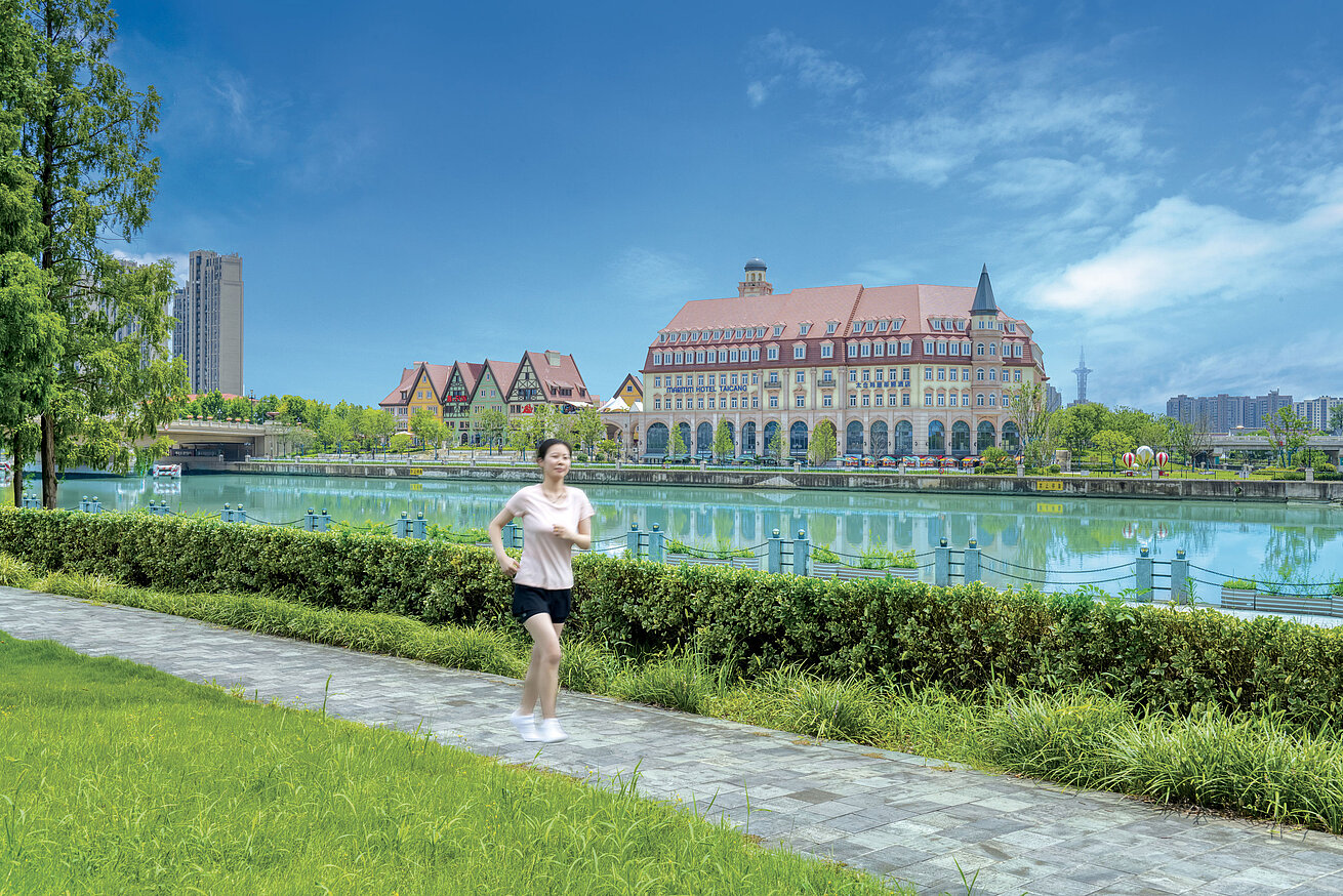 Female jogger running along the waterfront with views of the hotel and city