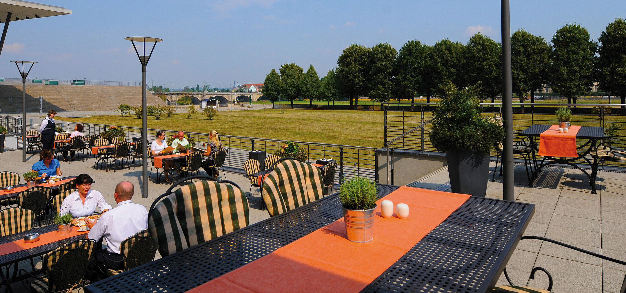 Sunny terrace of the Wintergarten Restaurant at the Maritim Hotel Dresden with a view of the Elbe meadows.