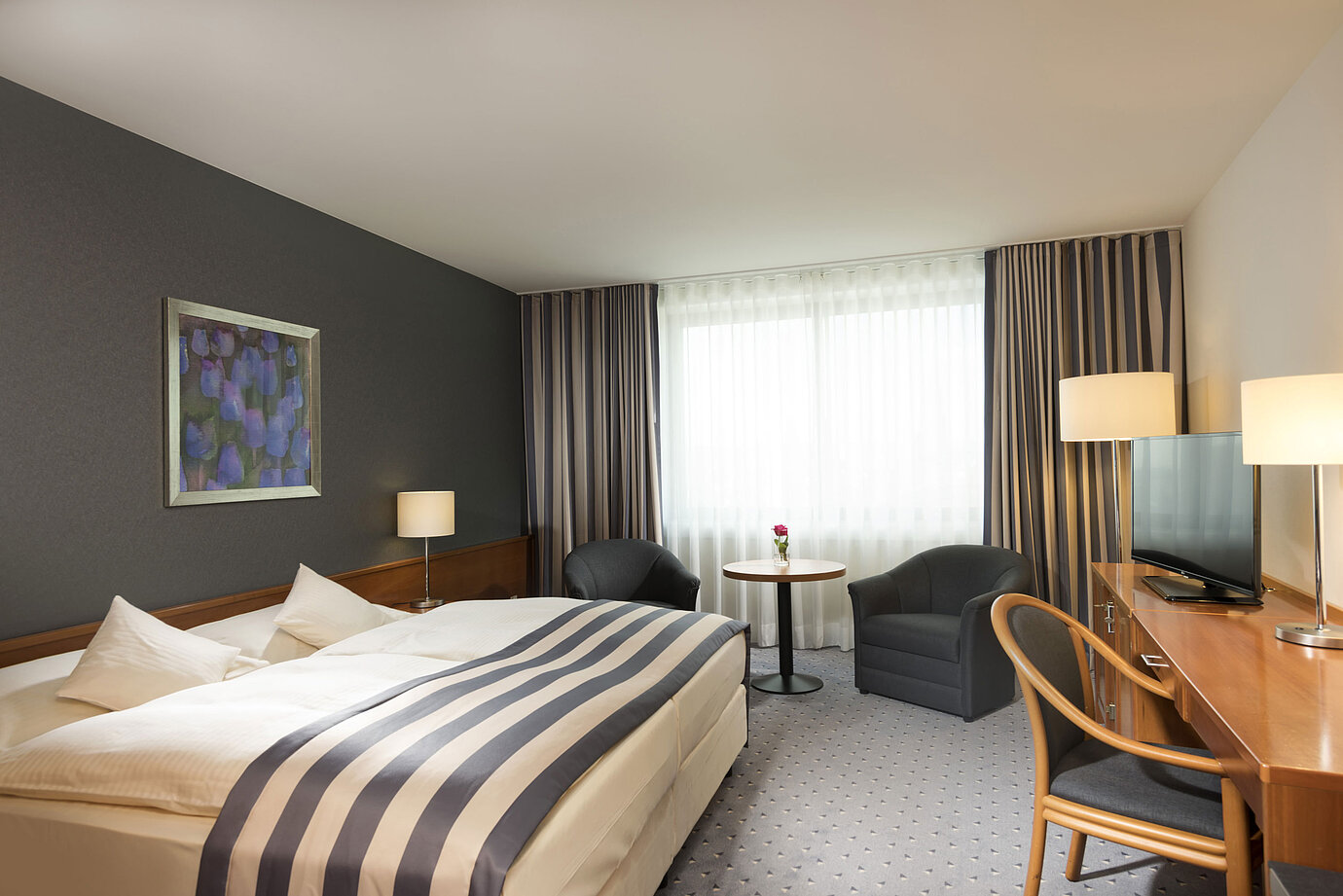 Spacious double room at Maritim Hotel Ulm with daylight, seating area and desk