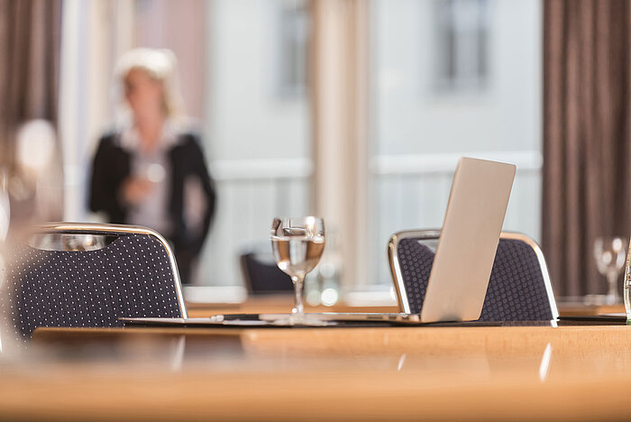 Close-up of a conference room at Maritim proArte Hotel Berlin, focusing on laptop and water glass.