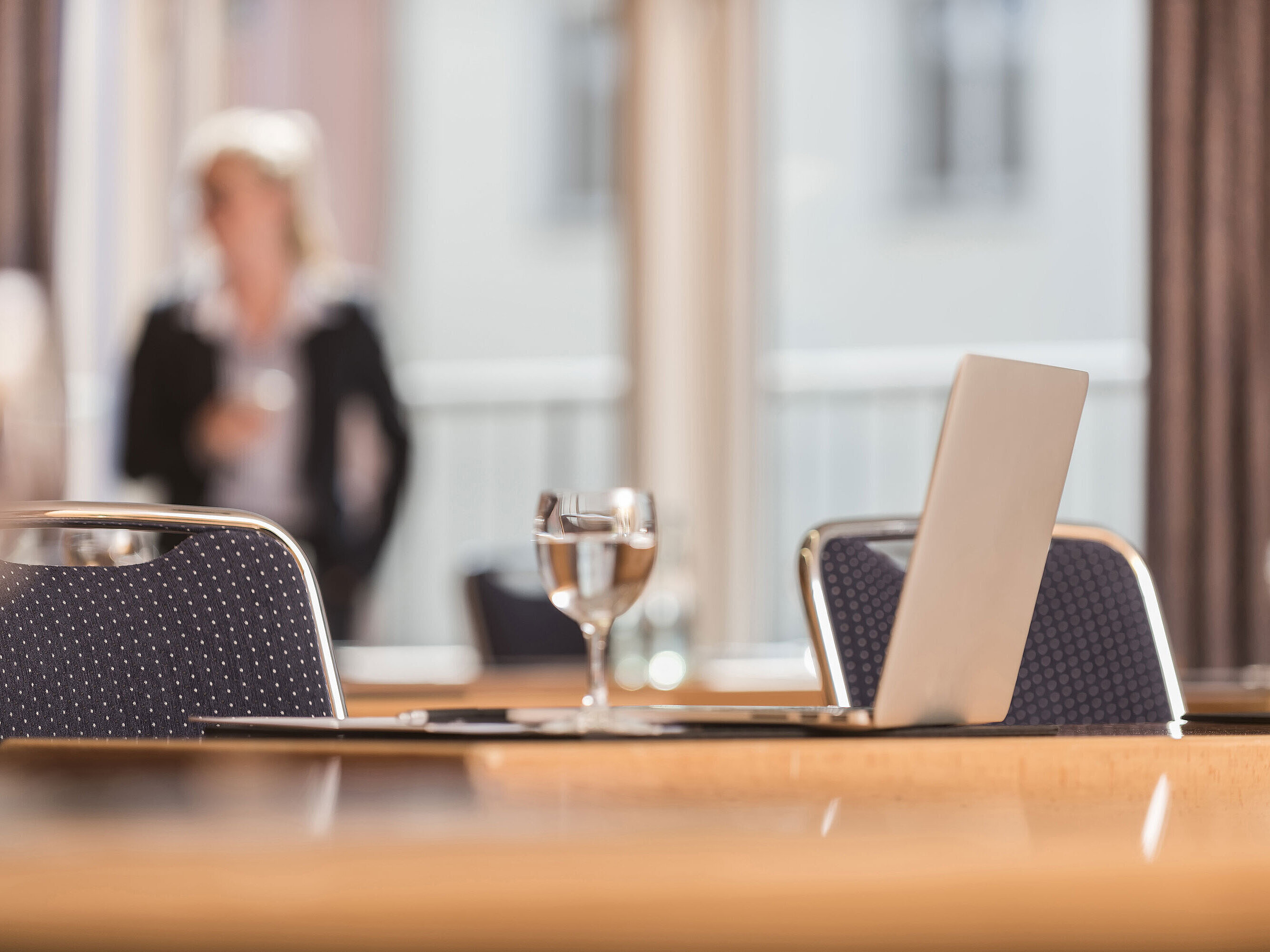 Close-up of a conference room at Maritim proArte Hotel Berlin, focusing on laptop and water glass.