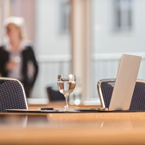 Close-up of a conference room at Maritim proArte Hotel Berlin, focusing on laptop and water glass.