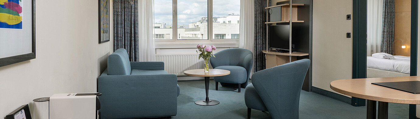 Bright suite with seating area, large window and coffee machine at Maritim proArte Hotel Berlin