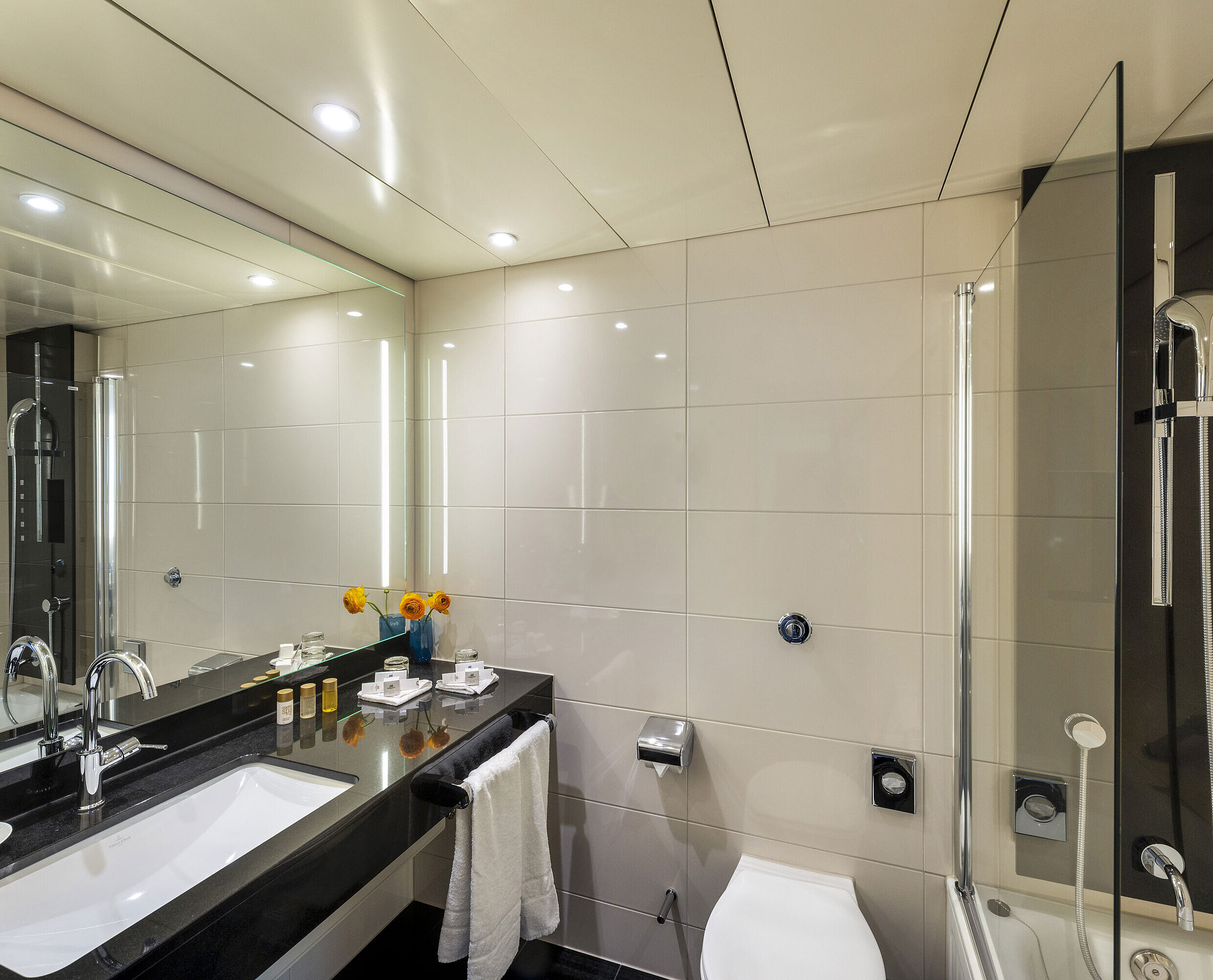 Modern bathroom with bathtub, large mirror, elegant fittings and premium amenities at Maritim Hotel Ulm.