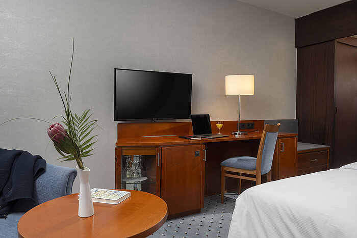 Workspace in the Classic room of Maritim Hotel Darmstadt with desk, TV, and modern furnishings.